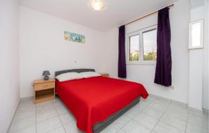 Un dormitorio con una cama roja y una ventana. en 2 Bedroom Amazing Apartment In Poljica, en Poljica