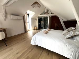 a bedroom with a white bed with a teddy bear on it at Rêves de Canopée in Le Loroux-Bottereau