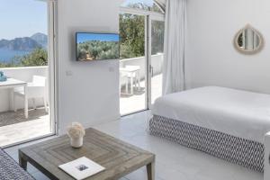 a white bedroom with a bed and a table at Relais Blu in Massa Lubrense