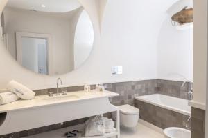 a bathroom with a sink and a tub and a mirror at Relais Blu in Massa Lubrense