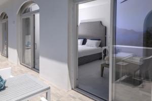 a room with a bed and a table and a glass door at Relais Blu in Massa Lubrense