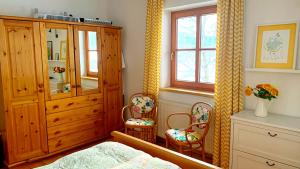 a bedroom with a wooden cabinet and two chairs at Bergzicht in Mariapfarr +9 photos