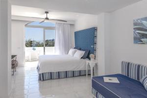 a white bedroom with a bed and a window at Relais Blu in Massa Lubrense