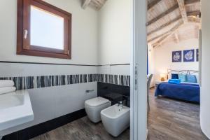 a bathroom with a toilet and a sink and a bed at Riva rooms - by Obiettivo vacanza Budoni in Budoni +47 photos