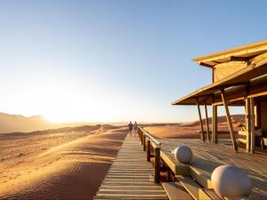 un paseo marítimo de madera en medio del desierto en Wolwedans Desert lodge, en NamibRand 4 fotos más