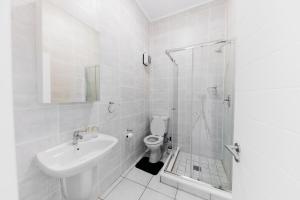 ein weißes Badezimmer mit Waschbecken und Toilette in der Unterkunft Orange Blossom Luxury Apartment in Sandton + 26 Fotos