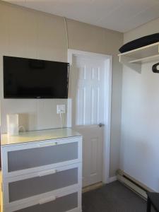 a room with a dresser with a tv on the wall at Balm Beach Resort and Motel in Balm Beach