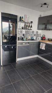 cocina con encimera y mesa en Sweet home avec vue incroyable lac leman! A l'entrée du Lavaux et proche lausanne, en Belmont-sur-Lausanne 9 fotos más