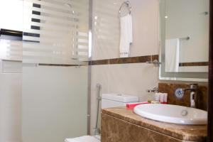 a bathroom with a sink and a toilet and a mirror at سمت الفيحاء للشقق المخدومة - Samt Al Fayhaa Serviced Apartments in Riyadh +32 photos