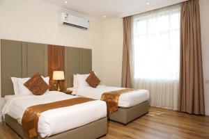 a hotel room with two beds and a window at سمت الفيحاء للشقق المخدومة - Samt Al Fayhaa Serviced Apartments in Riyadh