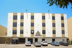 a building with cars parked in front of it at سمت الفيحاء للشقق المخدومة - Samt Al Fayhaa Serviced Apartments in Riyadh