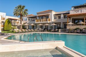 a hotel with a swimming pool in front of a building at Aegean Houses in Kos