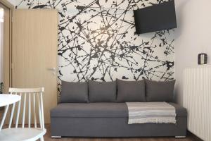a living room with a couch in front of a wall at Cocoon Urban Suites in Kavála