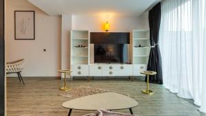 a living room with a tv and a white entertainment center at Zen Retreat Studio in Silver Mountain in Poiana Brasov