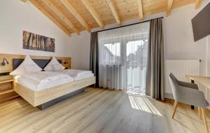 a bedroom with a bed and a desk and a window at Maxlwirt - Gasthaus Pension Gibis in Mauth +5 photos