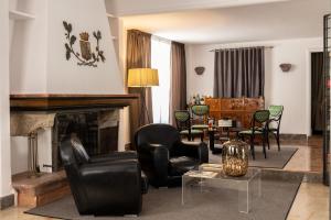 a living room with black chairs and a fireplace at Hotel Principe Di Villafranca in Palermo