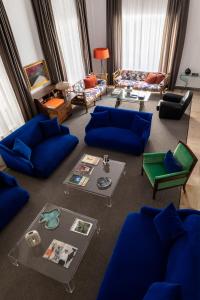 a living room with blue couches and a table at Hotel Principe Di Villafranca in Palermo +27 photos