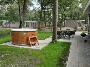 a hot tub in a yard with a table and chairs at Boshuisje met hottub in Haarle