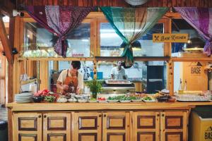 a man standing in a kitchen preparing food at Base Bungalows in Olympos