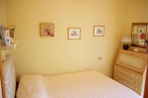 a bedroom with a bed and a wooden dresser at Casetta in Versilia in Viareggio