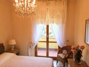 a bedroom with a bed and a window with a chandelier at Casetta in Versilia in Viareggio