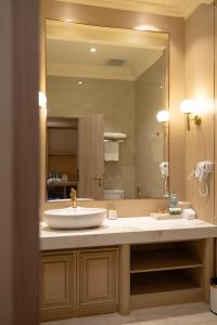 a bathroom with a sink and a large mirror at Whistler Garden Hotel in Sungaitahang