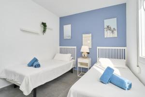 2 łóżka w pokoju z niebieskimi ścianami w obiekcie Wonderful Villa Burriana Beach w mieście Nerja
