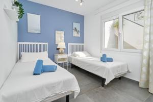 2 łóżka w pokoju z niebieskimi ścianami w obiekcie Wonderful Villa Burriana Beach w mieście Nerja +30 zdjęć