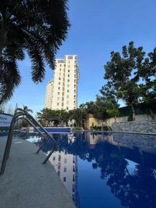 a building and a swimming pool in front of a building at Anuva Condo Staycation and Rent in Manila