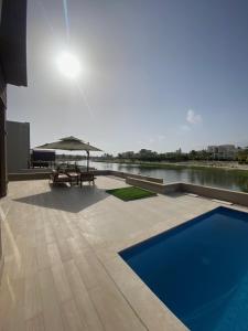 a patio with a picnic table and a blue pool at Villa Rotana Tulip in Salalah