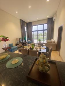 a dining room and living room with tables and chairs at Villa Rotana Tulip in Salalah