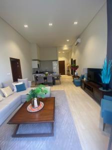 a living room with a white couch and a table at Villa Rotana Tulip in Salalah