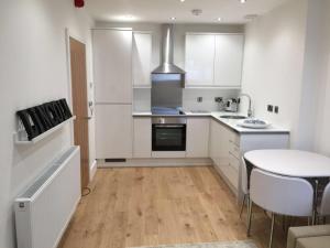 a kitchen with white cabinets and a table in it at Lincoln Retreat in Lincoln