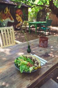 a plate of food on a wooden table with a salad at Base Bungalows in Olympos +56 photos