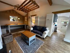 a living room with a couch and a table at Nature lovers retreat - New Forest in Ibsley