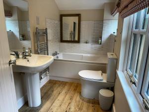 a bathroom with a sink and a tub and a toilet at Nature lovers retreat - New Forest in Ibsley +19 photos