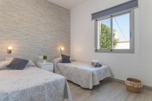 Un dormitorio con dos camas y una ventana. en Villa el Olivar 1, en Barbate 17 fotos más