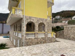 a yellow building with a balcony on the side of it at Hara Villa in Bijela