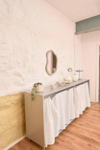 a long counter with a mirror and a sink at Platz für alle - geschmackvolle Gruppenunterkunft in Plagwitz