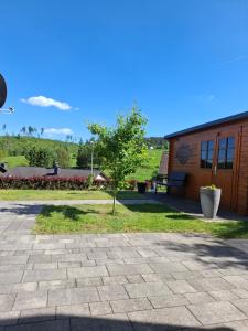 a building with a tree in front of it at Ferienwohnung Im Wiesenrain in Hausen-Wied