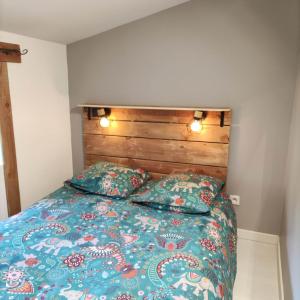a bedroom with a bed with a wooden headboard and pillows at Brin d'Ardèche in Saint-Prix