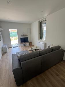 una sala de estar con un sofá y una mesa en Villa LARRIEU, en Toulouse