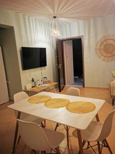a dining room with a white table and chairs at Xaido's House near airport port sea in Artemida