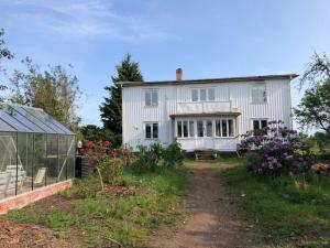 a white house with a garden and a greenhouse at Bockekulla Gård in Bergkvara