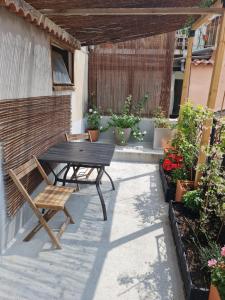 a patio with a table and a bench and potted plants at La Cardabelle in Moulinet