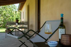 a bottle of wine sitting on a chair with a glass at Boutique Bio Agriturismo Casale San Cristoforo in Città di Castello +51 photos