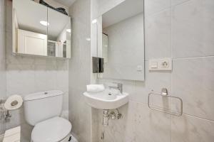 a white bathroom with a toilet and a sink at El Mirador de la Estafeta by Clabao in Pamplona +21 photos