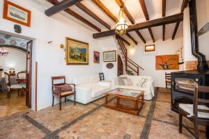 a living room with a white couch and a table at Cas Patró Lau Bis in Fornalutx