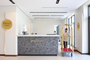 a man standing at a counter in a lobby with a counter sidx sidx at سمت الربوة للشقق المخدومة -Samt Al Rabwah Serviced Apartments in Riyadh