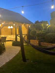 a hammock in a garden at night with lights at Domki I Pokoje Gościnne Marika in Bobolin